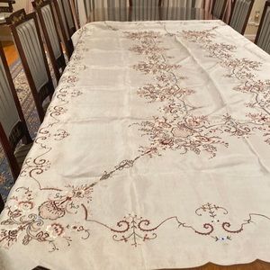 A rectangular table cloth in beige color with beautiful embroidery